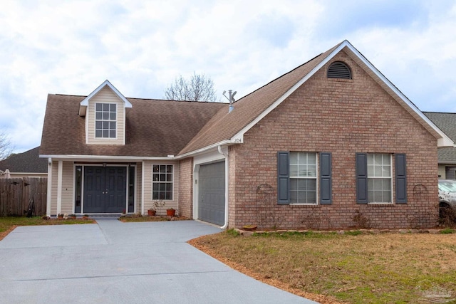 new england style home featuring a garage, brick siding, fence, driveway, and a front yard