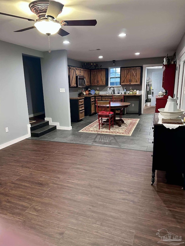 dining room with ceiling fan and dark hardwood / wood-style flooring