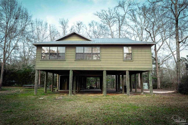 view of front of house featuring a carport, metal roof, and a front lawn