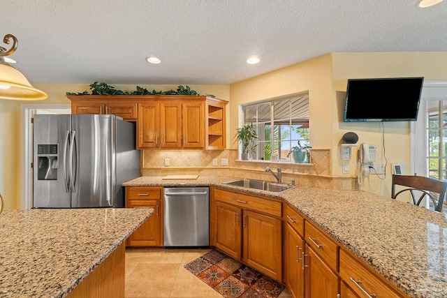 kitchen with sink, stainless steel appliances, light stone counters, and tasteful backsplash