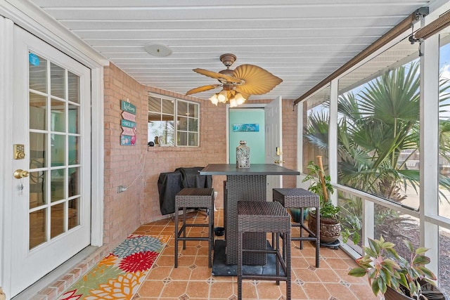 sunroom featuring ceiling fan and plenty of natural light