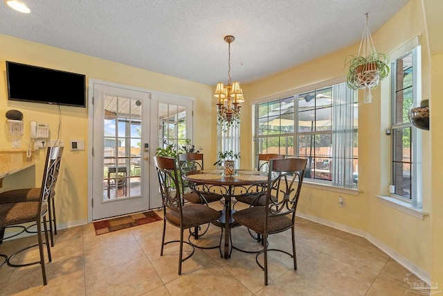 dining room featuring light tile patterned floors, a chandelier, a textured ceiling, and a healthy amount of sunlight