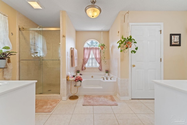 bathroom featuring tile patterned flooring, independent shower and bath, a textured ceiling, and vanity