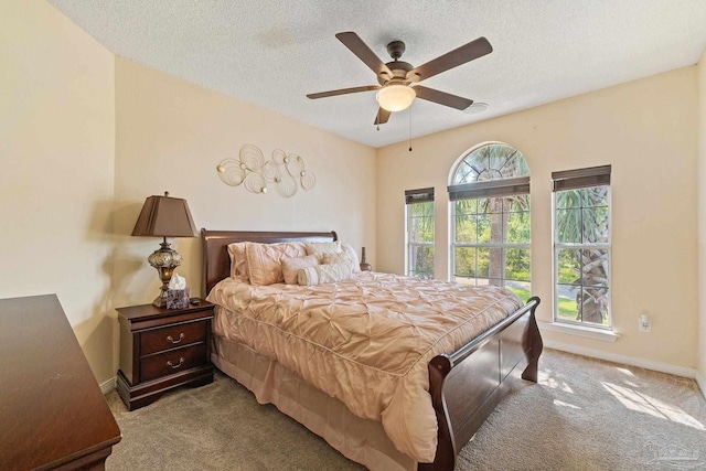 carpeted bedroom featuring a textured ceiling and ceiling fan