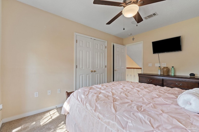 bedroom with ceiling fan, light colored carpet, and a closet