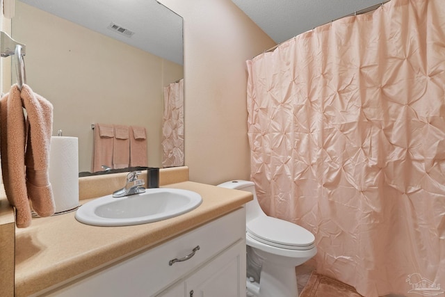 bathroom featuring tile patterned floors, a textured ceiling, vanity, and toilet