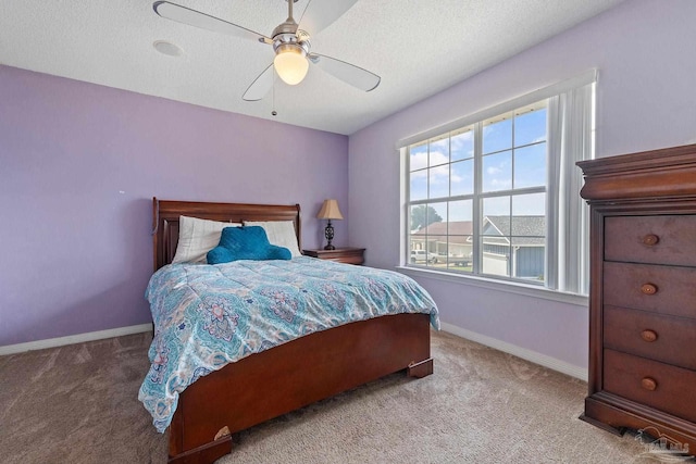 bedroom with a textured ceiling, ceiling fan, and light colored carpet