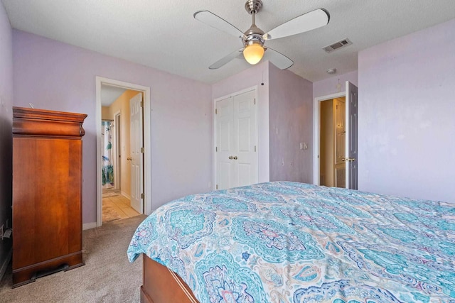 carpeted bedroom featuring ceiling fan and a textured ceiling