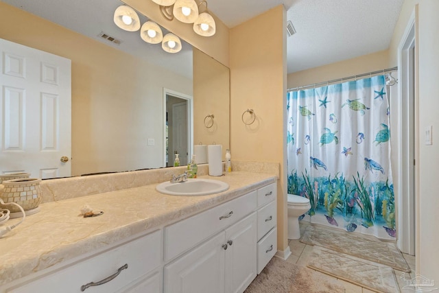 bathroom with tile patterned floors, toilet, a textured ceiling, and vanity