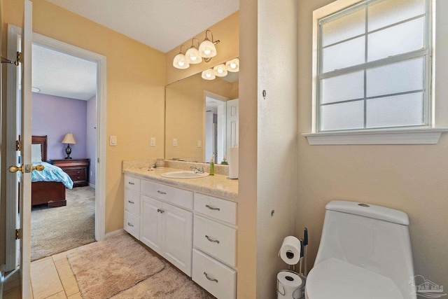 bathroom featuring a textured ceiling, toilet, vanity, and tile patterned floors