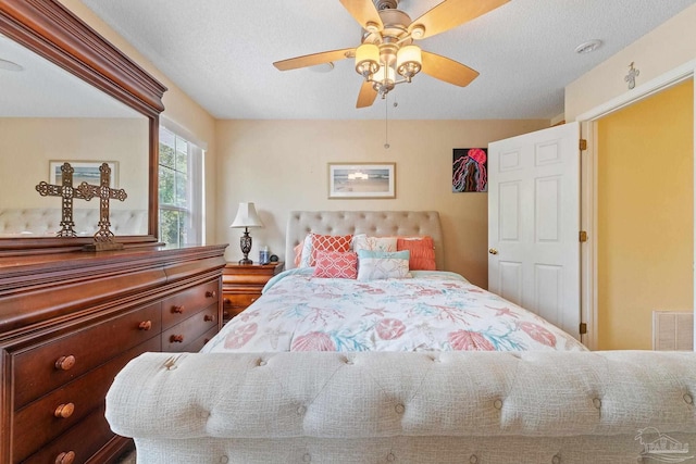 bedroom featuring ceiling fan and a textured ceiling