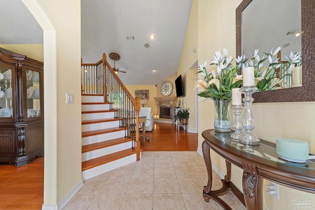 entrance foyer with light wood-type flooring and high vaulted ceiling