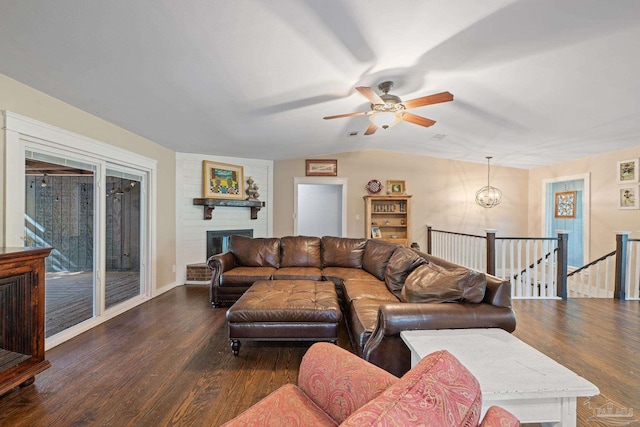 living room featuring ceiling fan, a large fireplace, dark wood-type flooring, and lofted ceiling