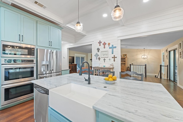 kitchen featuring light stone countertops, appliances with stainless steel finishes, sink, beamed ceiling, and hanging light fixtures