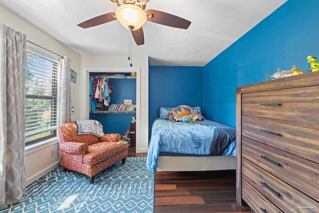 bedroom with dark hardwood / wood-style flooring, a closet, and ceiling fan