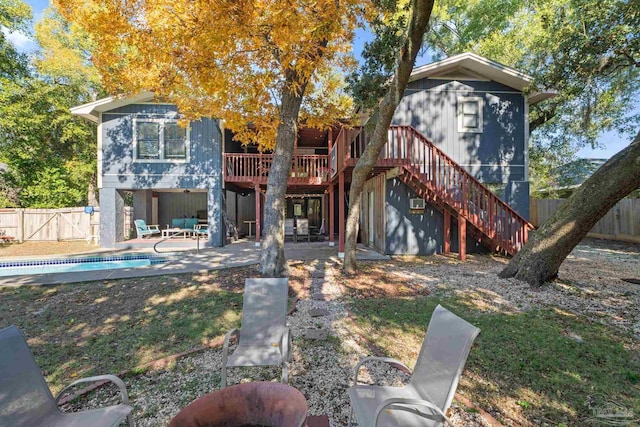 rear view of property featuring a patio and a pool side deck