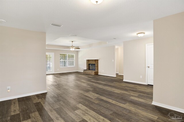 6459 E Quarry Dr, Elberta, AL 36530 - unfurnished living room with a ceiling fan, dark wood finished floors, a fireplace, and baseboards