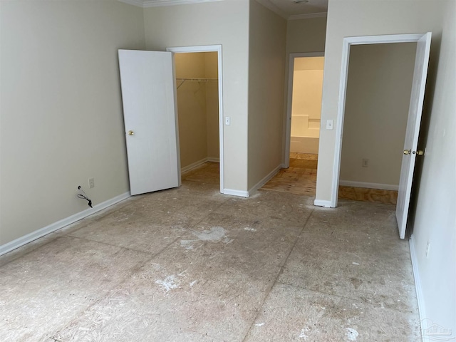 unfurnished bedroom featuring a walk in closet, ornamental molding, and a closet