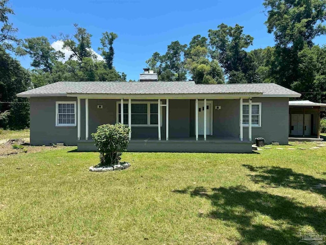 rear view of property with a lawn