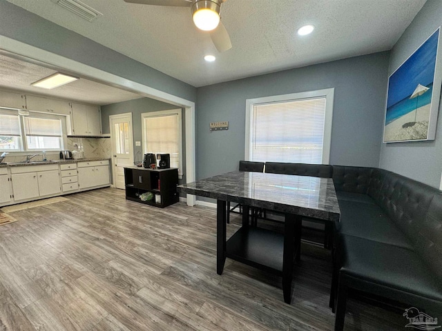 dining area featuring a textured ceiling, ceiling fan, and hardwood / wood-style flooring