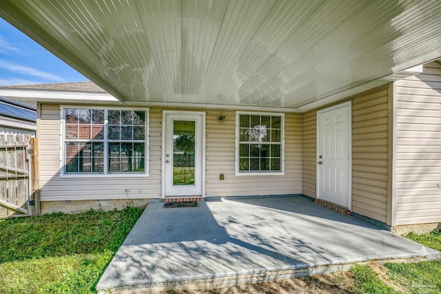 doorway to property with fence and a patio