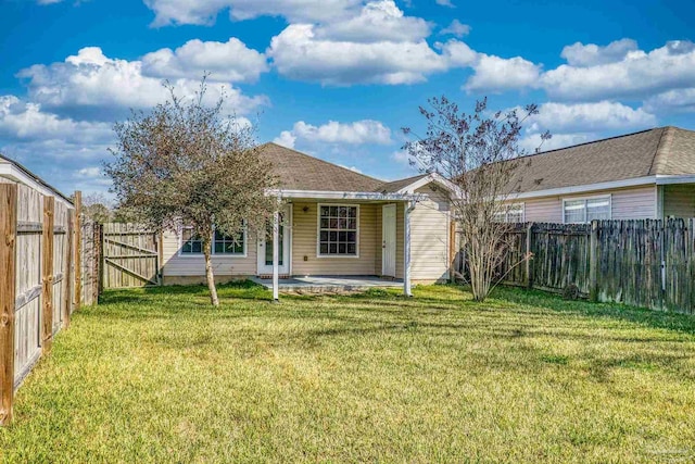 back of property featuring a fenced backyard, a lawn, and a patio