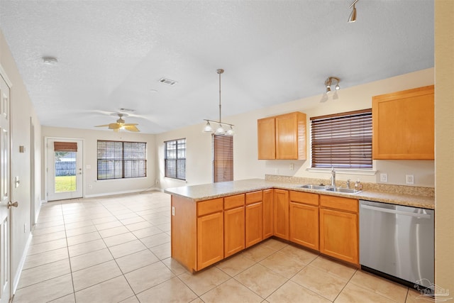 kitchen featuring light tile patterned floors, a peninsula, light countertops, stainless steel dishwasher, and a sink