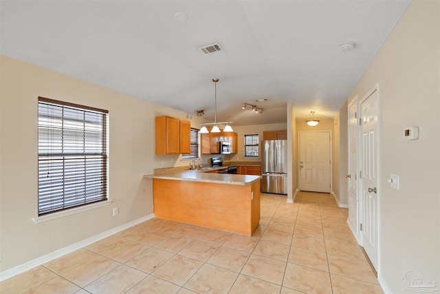 kitchen with light tile patterned floors, a peninsula, a sink, visible vents, and appliances with stainless steel finishes