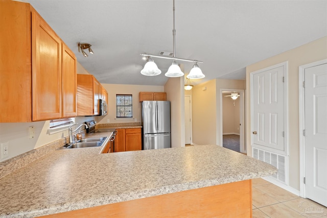 kitchen with a peninsula, appliances with stainless steel finishes, light countertops, and light tile patterned flooring