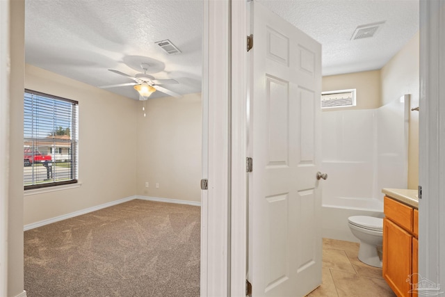 bathroom with a textured ceiling, vanity, visible vents, and a healthy amount of sunlight