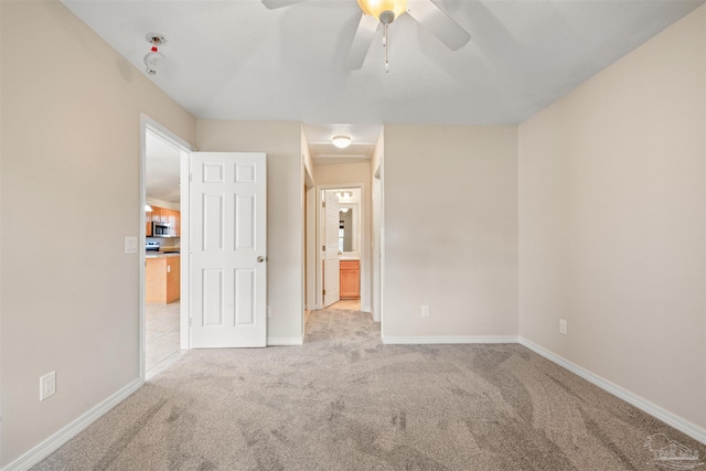 unfurnished bedroom with carpet, a ceiling fan, and baseboards