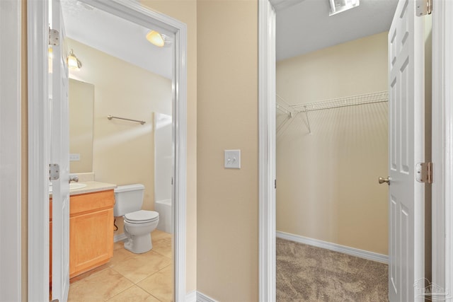 bathroom featuring a walk in closet, visible vents, toilet, vanity, and tile patterned floors