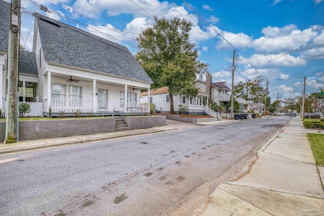 view of street with a residential view, curbs, and sidewalks