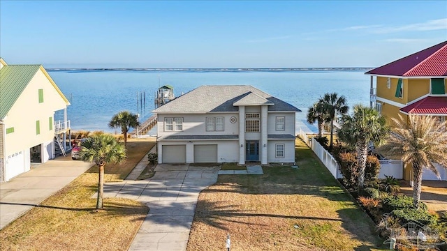 view of front of home with a garage, a water view, and a front yard