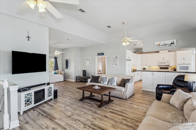 living room with light hardwood / wood-style floors and ceiling fan