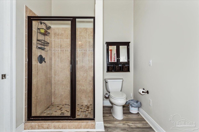 bathroom with toilet, hardwood / wood-style floors, and a shower with shower door