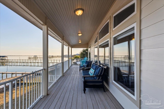 deck at dusk featuring a water view