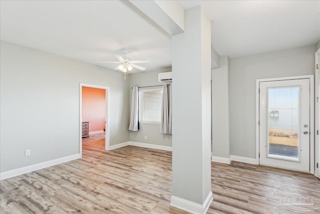 entryway featuring ceiling fan, light wood-type flooring, and a wall unit AC