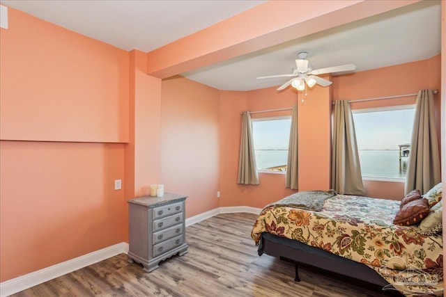 bedroom featuring multiple windows, ceiling fan, and light wood-type flooring