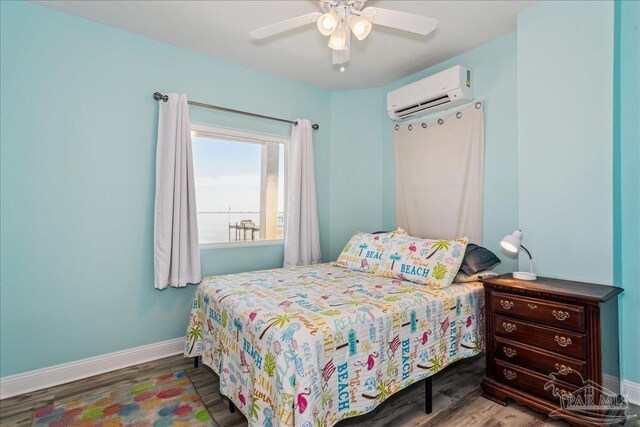 bedroom with hardwood / wood-style flooring, ceiling fan, and a wall mounted AC