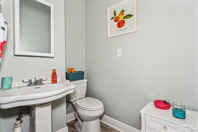 bathroom featuring hardwood / wood-style flooring and toilet