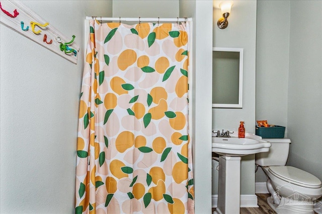 bathroom featuring hardwood / wood-style flooring, toilet, and walk in shower