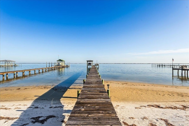 dock area featuring a water view and a view of the beach