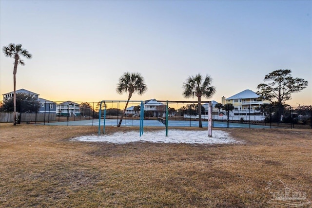 playground at dusk featuring a lawn