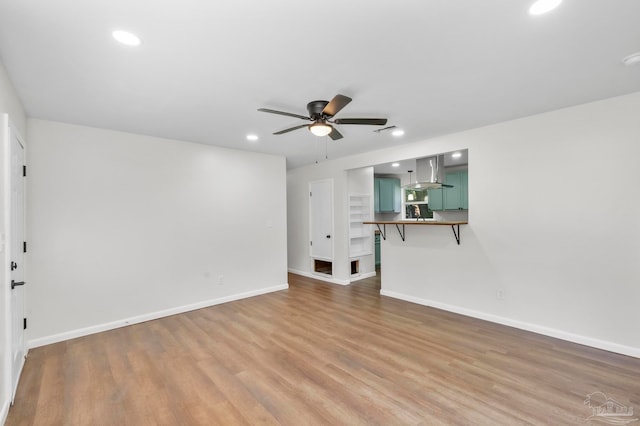 unfurnished living room featuring hardwood / wood-style flooring and ceiling fan