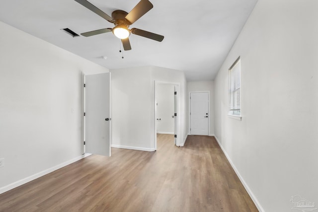 empty room with hardwood / wood-style floors and ceiling fan