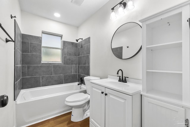 full bathroom with toilet, hardwood / wood-style floors, vanity, and tiled shower / bath