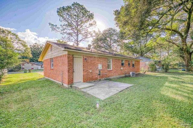 rear view of house with a lawn, a patio, and central AC unit