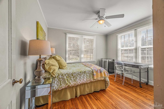 bedroom with baseboards, wood finished floors, and ornamental molding