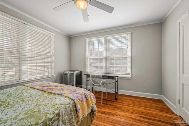 bedroom with a ceiling fan, ornamental molding, baseboards, and wood finished floors